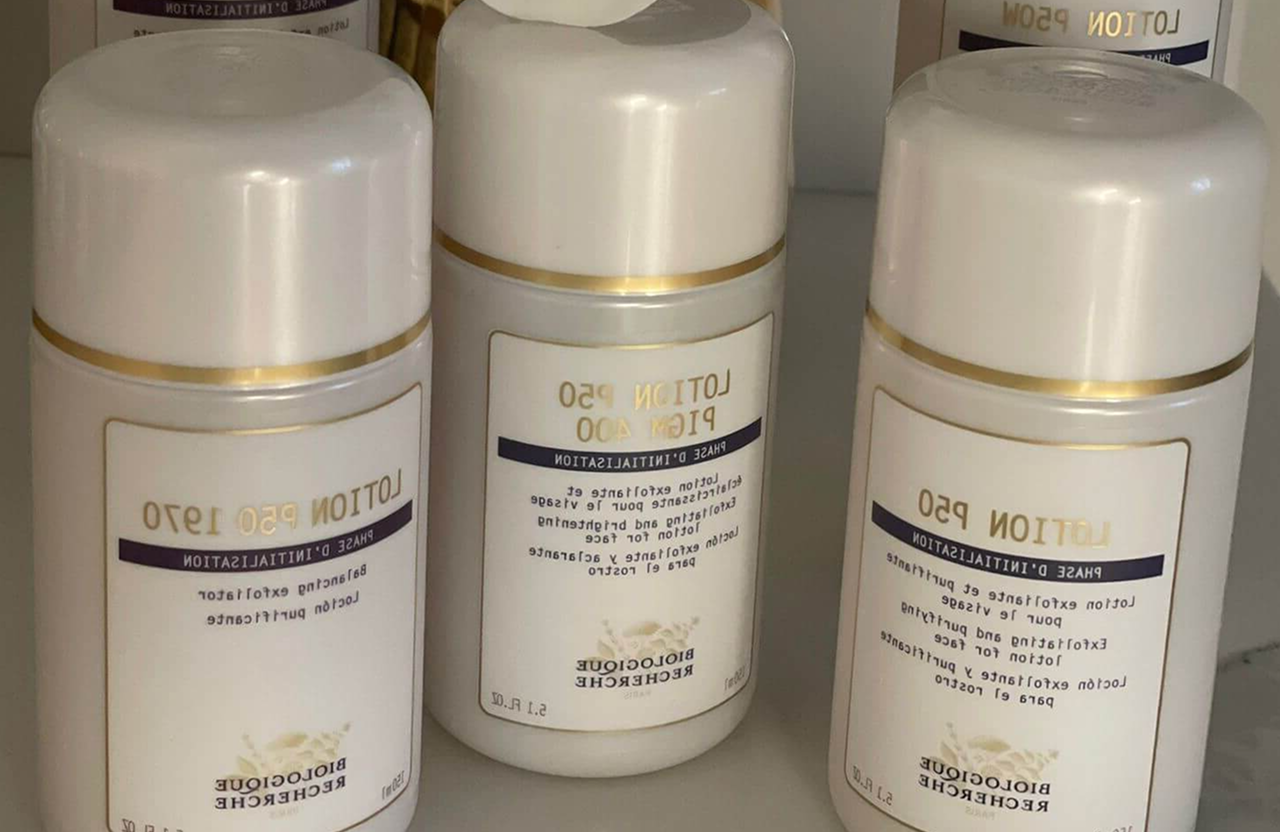 Lydia Esthetics Embassy Four bottles of Biologique Recherche Lotion P50 skincare product are arranged upright on a shelf, with labels visible. New York